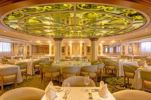 ein Restaurant mit weißen Tischen und Stühlen und einer großen Decke in der Unterkunft Sonesta St George Nile Cruise - Aswan to Luxor 3 Nights from Friday to Monday in Assuan