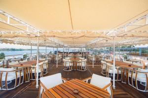 ein Restaurant mit Holztischen und weißen Stühlen in der Unterkunft Sonesta St George Nile Cruise - Aswan to Luxor 3 Nights from Friday to Monday in Assuan + 89 Fotos