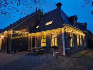 a brick house with christmas lights on it at Logement Alde Leie in Alde Leie