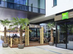 a restaurant with palm trees in front of a building at ibis Styles Liege Guillemins in Liège