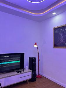 イバダンにあるLOJ Homesのリビングルーム(テレビ、ランプ、テーブル付)