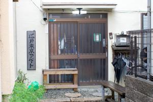 un ingresso di un edificio con un cancello e una panchina di Edo Tokyo Sharehouse Long Stay Only, One month plus a Tokyo