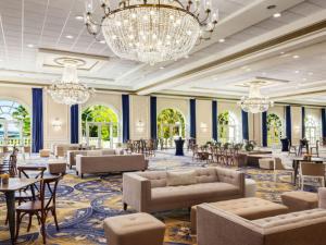eine große Lobby mit Sofas, Tischen und Kronleuchtern in der Unterkunft Fairmont El San Juan Hotel in San Juan