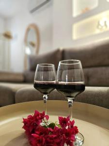 two glasses of wine on a table with flowers at Apartamentos Casa del Mar in Torrevieja