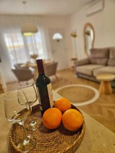 a bottle of wine and oranges on a table in a living room at Apartamentos Casa del Mar in Torrevieja
