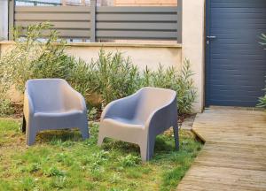 ルマンにあるLe Confort T2 tout équipé, proche Gare, Centre ville, Circuit des 24Hの家の横の芝生に座る椅子2脚