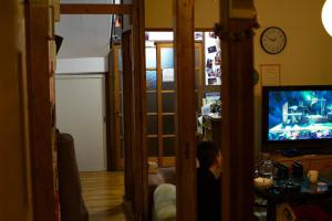 un ragazzo seduto davanti alla televisione in un soggiorno di Edo Tokyo Sharehouse Long Stay Only, One month plus a Tokyo