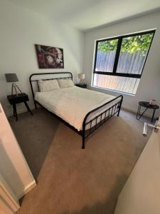 ein Schlafzimmer mit einem Bett und einem großen Fenster in der Unterkunft Beautiful light filled modern apartment in Kew in Melbourne