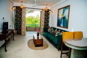 ein Wohnzimmer mit einer grünen Couch und einem Tisch in der Unterkunft Sithagi River Front Villa Weligama in Nikawatawana