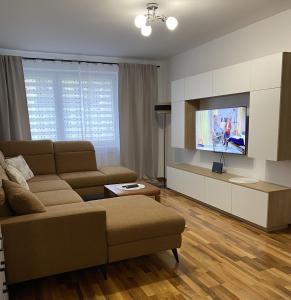 a living room with a couch and a flat screen tv at Apartament Wysoka Brama in Lidzbark Warmiński
