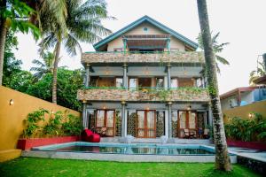 ein Haus mit Palmen davor in der Unterkunft Sithagi River Front Villa Weligama in Nikawatawana