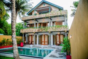 ein Haus mit einem Swimmingpool davor in der Unterkunft Sithagi River Front Villa Weligama in Nikawatawana