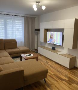 a living room with a couch and a flat screen tv at Apartament Wysoka Brama in Lidzbark Warmiński
