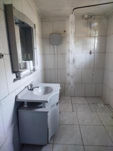 a white bathroom with a sink and a mirror at Quarto N II Cama Individual e sofá cama solteiro in Gramado