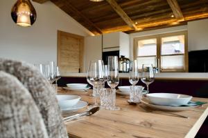 a wooden table with glasses and bowls and plates on it at Appartement Oberschernthann in Hopfgarten im Brixental +56 photos
