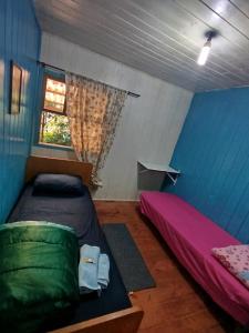 a room with two beds and a window at Quarto N II Cama Individual e sofá cama solteiro in Gramado +4 photos