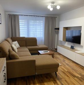 a living room with a couch and a flat screen tv at Apartament Wysoka Brama in Lidzbark Warmiński