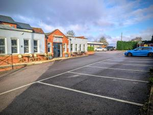 an empty parking lot with a blue car parked in it at The Maypole at Wellow in Ollerton