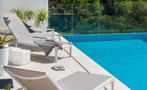 eine Gruppe von Stühlen neben einem Swimmingpool in der Unterkunft Ferienhaus mit Privatpool für 8 Personen ca 200 m in Veliko Brdo, Dalmatien Biokovo-Gebirge in Veliko Brdo + 32 Fotos