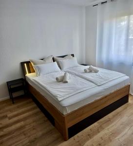 a large bed with white sheets and white pillows at Pfalz Studio in Speyer - stilvoll, modern & zentral in Speyer