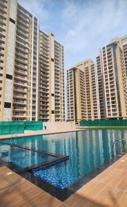 a large swimming pool in front of tall buildings at Vaibhav Stays in Nalmatha