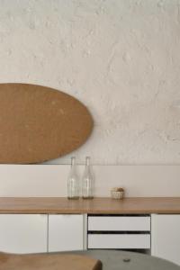 two glass bottles sitting on top of a wooden table at Grange habitée, nature & design in Manou +85 photos