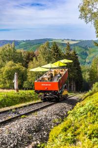 un train avec des gens assis dessus sur les rails dans l'établissement Flair-Hotel Waldfrieden, à Meuselbach-Schwarzmühle