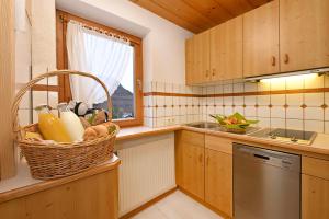 a kitchen with a basket of groceries on a counter at Rundblick 3 Panorama Klein in Tschagguns