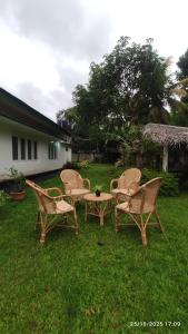 a group of chairs and a table in the grass at EVOKE Hostel Mirissa in Mirissa