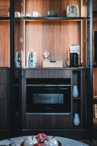una cocina con horno negro en un armario de madera en Appartements d'exception René & Victoire, en Épinal