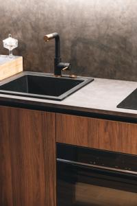 cocina con fregadero negro y encimera en Appartements d'exception René & Victoire, en Épinal