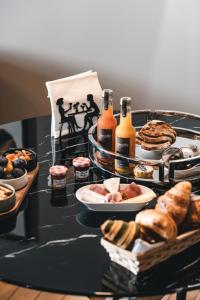 una mesa cubierta con platos de comida y botellas de cerveza en Appartements d'exception René & Victoire, en Épinal 14 fotos más