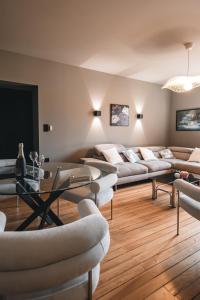 Una sala de estar con sofás y una mesa y sillas. en Appartements d'exception René & Victoire, en Épinal