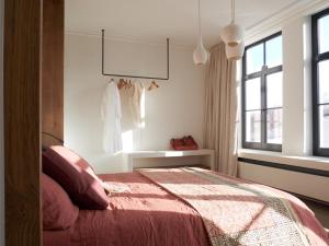 布鲁日guesthouse 't Kleihuys的卧室里有一张床，上面铺着一条红毯子