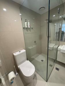 ein Badezimmer mit Toilette und Glasdusche in der Unterkunft Beautiful light filled modern apartment in Kew in Melbourne + 40 Fotos