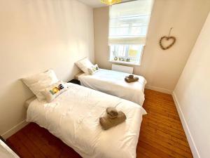 Le Wim Break, Centre et Mer à 2 pas في ويميريوكس: سريرين في غرفة صغيرة بها نافذة