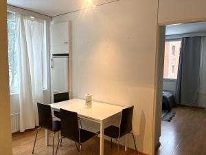 - une table et des chaises blanches dans la chambre dans l'établissement Kotimaailma - Tilava kaksio Kotkan Rauhalassa, à Kotka