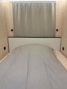 a bed in a small room with a window at Luxurious houseboat for up to 4 people in Dausenau