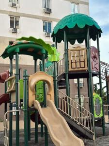 SubaCozy Studio with Balcony and Pool Near Airport and Beaches的大楼前带滑梯的游乐场