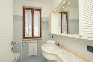 a bathroom with a sink and a toilet and a mirror at Casa Chiaretto in Moniga +28 photos