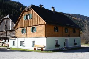 ein großes Haus mit einem Holzdach darauf in der Unterkunft Ferienwohnung Schaupphof in Donnersbachwald
