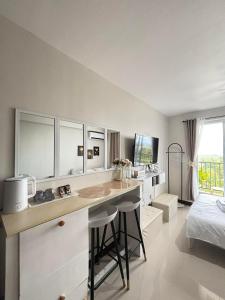 SubaCozy Studio with Balcony and Pool Near Airport and Beaches的一个带书桌的厨房和一张位于客房内的床