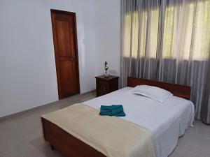 Un dormitorio con una cama con un lazo azul. en Yelona Rest, en Galle 10 fotos más