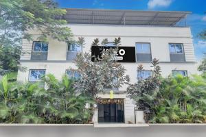 Un edificio bianco con un cartello nero sopra di Super Hotel O Khadakwasla Lakeview Formerly Gokul Lodge a Kharakvasla