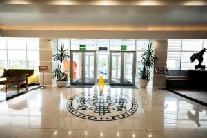 eine Lobby mit einer Uhr in der Mitte eines Gebäudes in der Unterkunft Hotel Dastan Aktobe in Aqtöbe