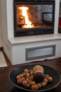 une assiette de noix sur une table devant une cheminée dans l'établissement Snow Chalets Parnassos Arachova's Nest, à Arachova 18 autres photos