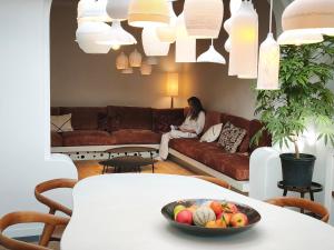 a woman sitting on a couch in a living room at guesthouse 't Kleihuys in Bruges