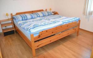 una cama de madera en una habitación con suelo de madera en Familie Frei, en Bever