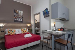 a living room with a red bed and a kitchen at Hotel apartments Crisvan in Rimini