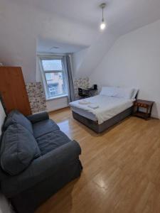 a living room with a bed and a couch at Princess Homestay in Sunderland
